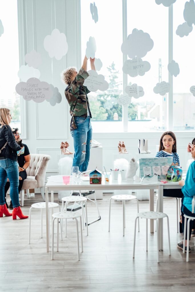 Workshops & Community Events – St Albans, Hertfordshire Community wellness workshop in St Albans, Hertfordshire with women decorating a bright room with positive messages.